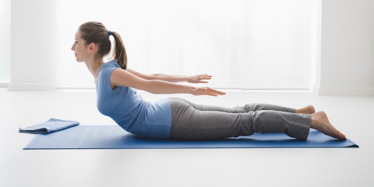 woman doing yoga locust pose